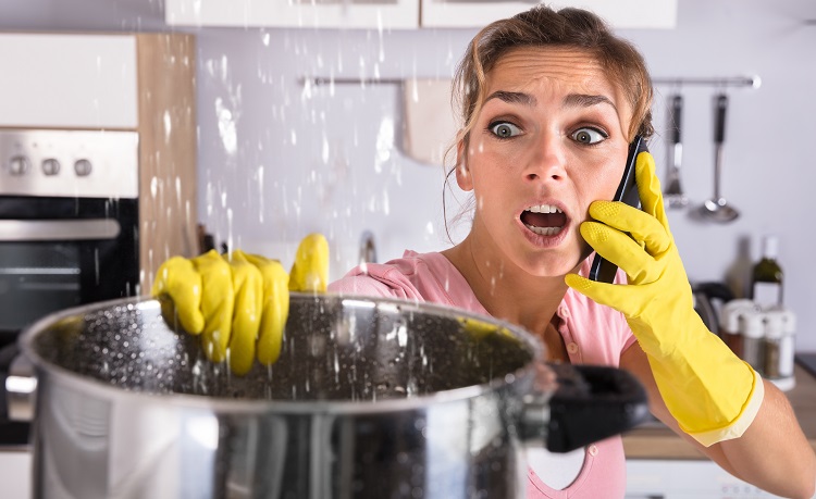 Woman Calling Plumber To Fix Water Leaking From Ceiling